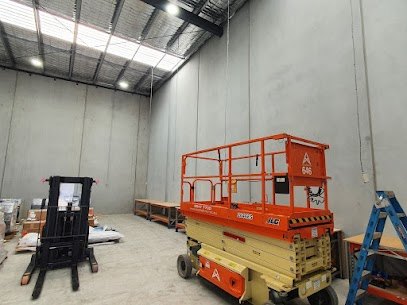 High warehouse ceiling with lights, beside a scissor lift