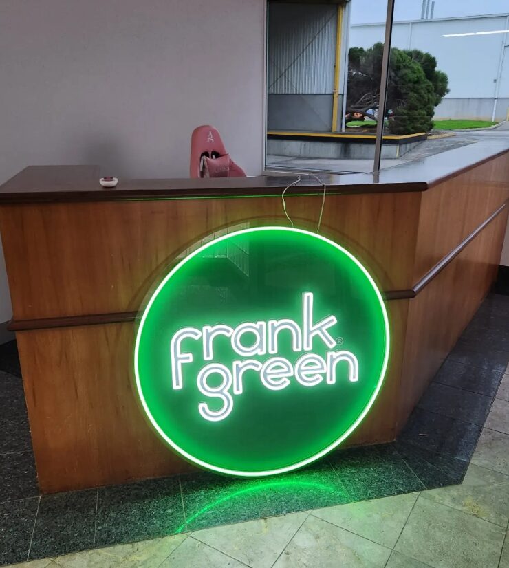 Illuminated round neon sign on the front of a timber reception desk